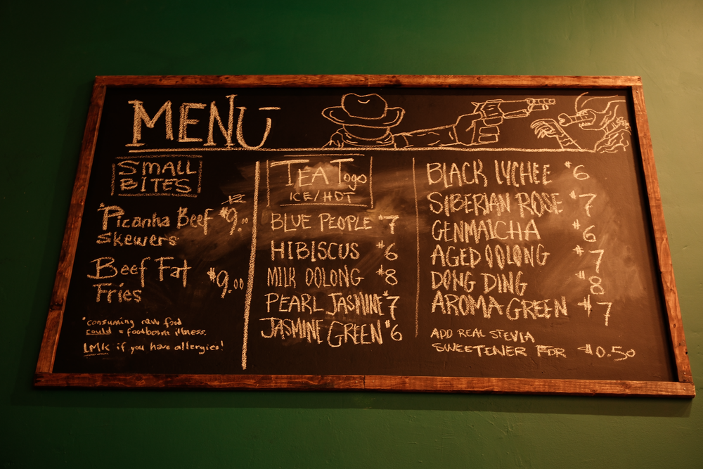 A large chalkboard containing menu items.